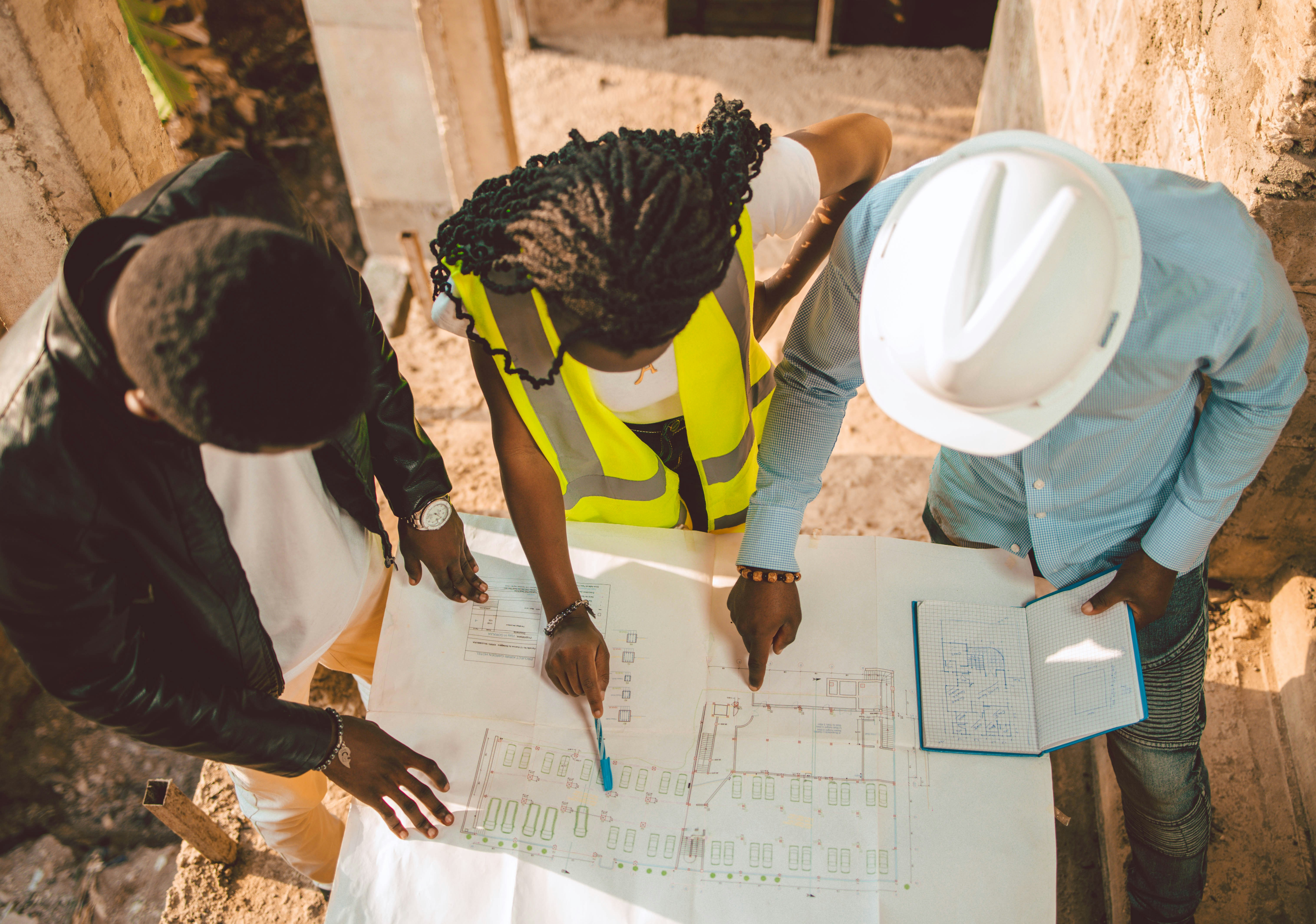 Illustrated site-planning scene with engineers, plans, and project analytics.